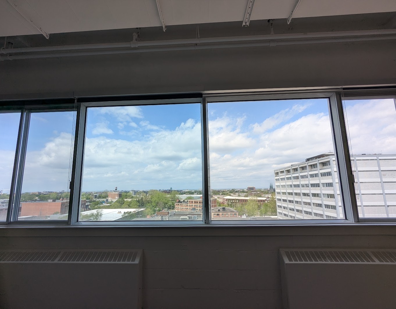 Bureaux à l'étage à Montréal, démonstration moitié-moitié de la membrane Low-E sur un bandeau de trois fenêtres
