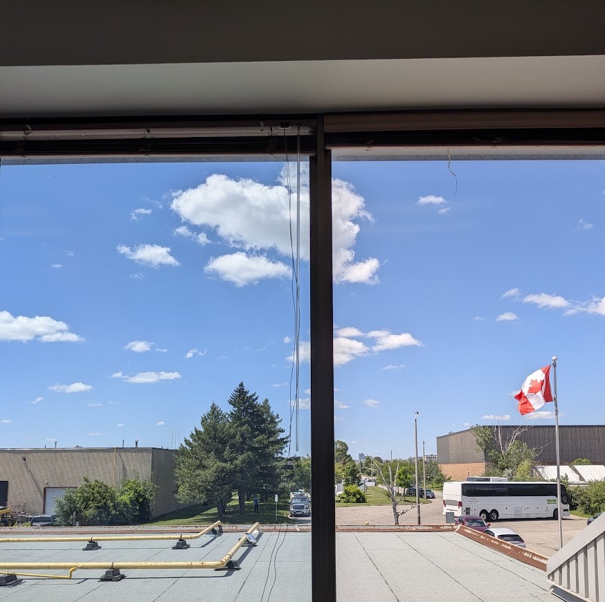 Bureaux commerciaux à Toronto, démonstration moitié-moitié de la membrane Low-E sur une fenêtre donnant sur un parc industriel