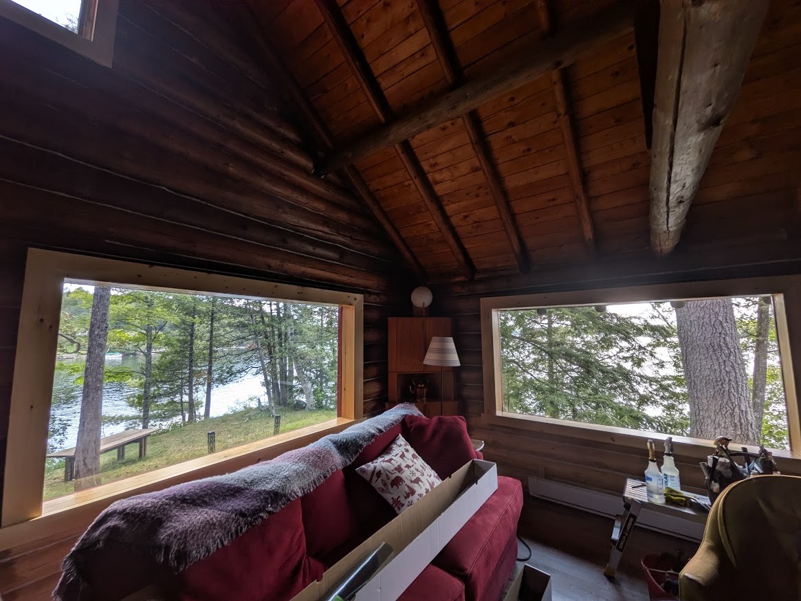 Chalet en bois rond en Ontario, membrane Low-E posée en moitié-moitié sur deux grandes fenêtres face au lac